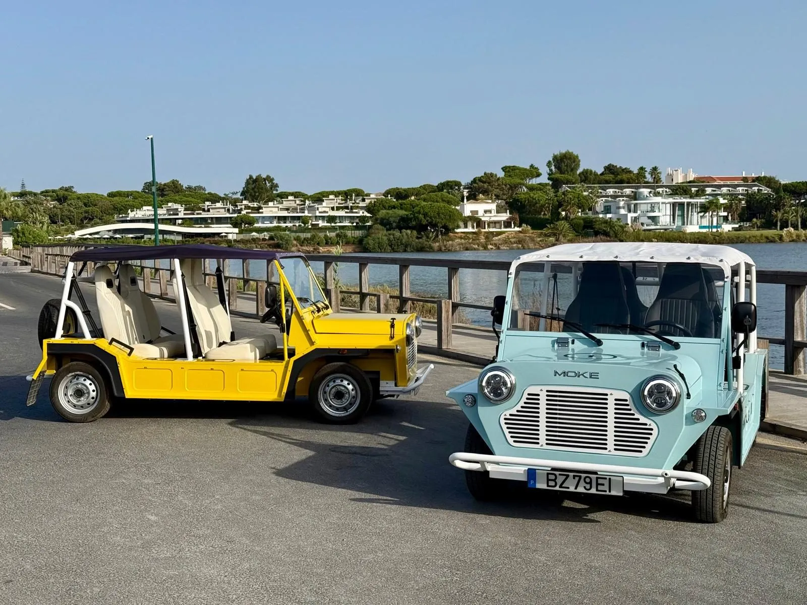 Yellow and pale blue Mokes on the waterfront in the Algarve